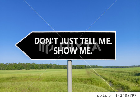 Tell or show symbol. Concept words Do not just tell me, show me beautiful black road sign. Beautiful blue sky green field background. Business tell or show concept. Copy space. Tell or show symbol. Concept words Do not just tell me, show me beautiful black road sign. Beautiful blue sky green field background. Business tell or show concept. Copy space. 142485797