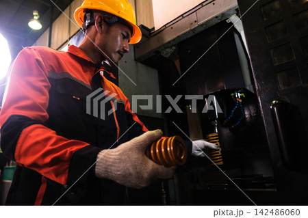 The engineer checks the parts coming out of the machine. The engineer checks the parts coming out of the machine. 142486060
