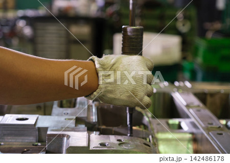 Engineers or workers are operating machinery in a factory. 142486178