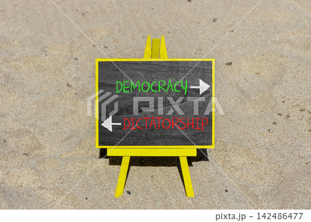 Democracy or dictatorship words symbol. Concept words Democracy Dictatorship on beautiful yellow blackboard. Beautiful sand beach background. Business democracy dictatorship concept. Copy space Democracy or dictatorship words symbol. Concept words Democracy Dictatorship on beautiful yellow blackboard. Beautiful sand beach background. Business democracy dictatorship concept. Copy space 142486477