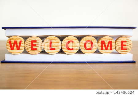 Welcome word symbol. Concept word Welcome on beautiful wooden circles in book. Beautiful wooden table white background. Business welcome word concept. Copy space. Welcome word symbol. Concept word Welcome on beautiful wooden circles in book. Beautiful wooden table white background. Business welcome word concept. Copy space. 142486524