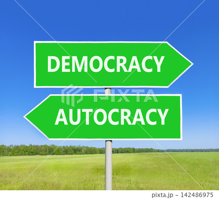 Democracy or autocracy words symbol. Concept words Democracy Autocracy on beautiful green road sign. Beautiful blue sky background. Business democracy autocracy concept. Copy space Democracy or autocracy words symbol. Concept words Democracy Autocracy on beautiful green road sign. Beautiful blue sky background. Business democracy autocracy concept. Copy space 142486975