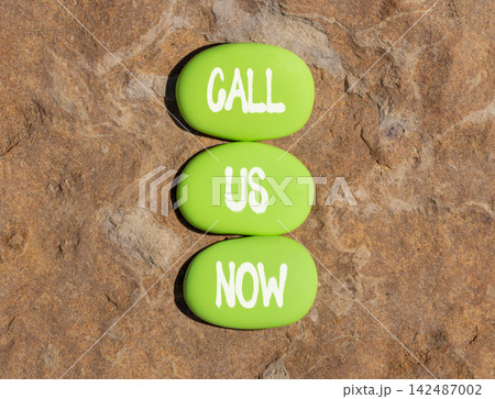 Call us now words symbol. Concept words Call us now on beautiful green stones. Beautiful stone background. Business support motivational and call us now concept. Copy space. 142487002
