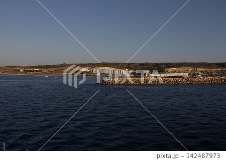 Panoramic view of Cirkewwa coast with resort hotel and breakwater from sea in Malta, June 19, 2026. Panoramic view of Cirkewwa coast with resort hotel and breakwater from sea in Malta, June 19, 2026. 142487973