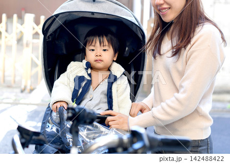 自転車に乗るアジア人の子供と支える母親 142488422