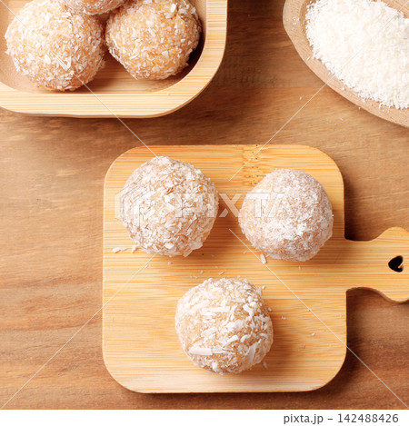 Traditional Brazilian beijinho sweet made with coconut, served on a bamboo board at parties and celebrations. 142488426