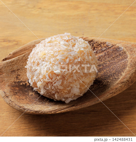 Homemade Brazilian coconut beijinho on a wooden spoon traditional sweets served at parties and celebrations. Homemade Brazilian coconut beijinho on a wooden spoon traditional sweets served at parties and celebrations. 142488431
