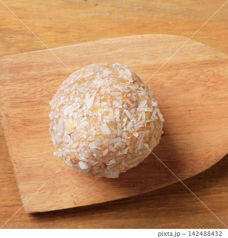 Homemade Brazilian coconut beijinho on a wooden spatula traditional sweets served at parties and celebrations. Homemade Brazilian coconut beijinho on a wooden spatula traditional sweets served at parties and celebrations. 142488432