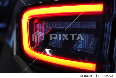 Lens blocks surrounded by red glowing lamps in a car backlight. Lens of modern vehicle light detailed image 142488998