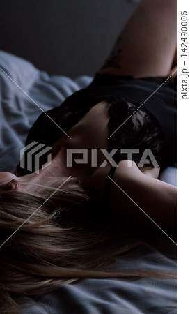 Sexy beautiful woman lies on the bed in a black erotic peignoir. Sexy beautiful woman lies on the bed in a black erotic peignoir. 142490006