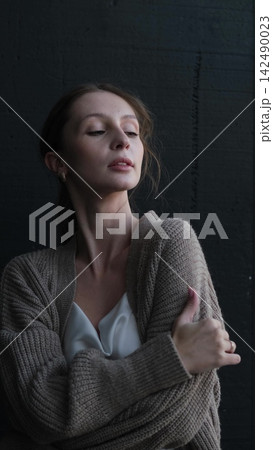 Portrait of a beautiful young girl on a dark studio background. Beautiful natural woman posing for the camera 142490023