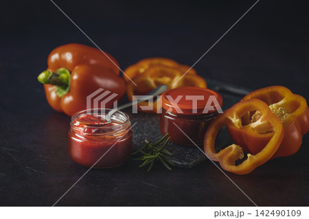Red bell pepper sauce with fresh ingredients and rosemary on dark background 142490109