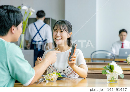 カフェでスマホを見る若いカップル 142491437