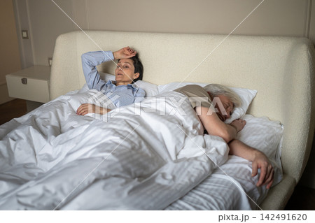 Worried senior woman cant sleep at night distracted by thoughts and fears of older husband betrayal. Worried senior woman cant sleep at night distracted by thoughts and fears of older husband betrayal. 142491620