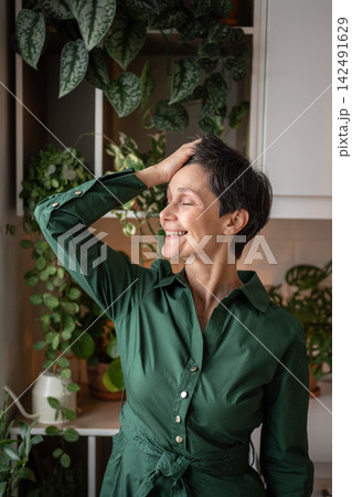Happy senior woman in kitchen smiling at home kitchen. Quiet start to day, Self care, day dreaming 142491629