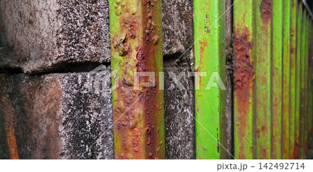 Rusty Green Metal Fence Bars Against Concrete Wall Rusty Green Metal Fence Bars Against Concrete Wall 142492714