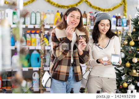 Women friends choose eyeshadow and lipstick in store 142493299