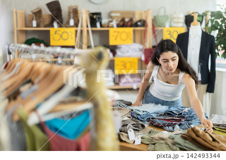 Woman in summer one chooses pants at a sale 142493344