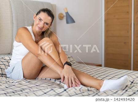 Woman in lingerie posing lying on bed at home 142493420