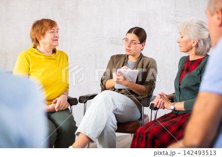 Young girl conducting language club for group of older adults Young girl conducting language club for group of older adults 142493513