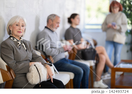 Elderly woman waiting in line during visit to medical center 142493724