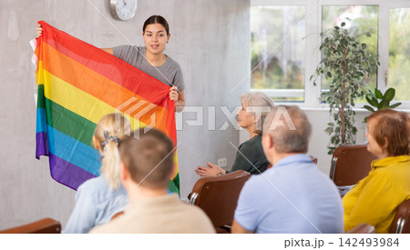 Young female tutor talking to group of seniors about LGBT movements 142493984