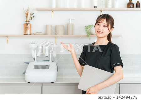 美容サロンで笑顔で迎えるエステティシャンの若い女性スタッフ 142494278