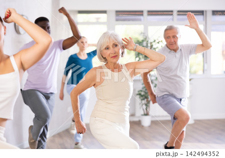 Senior woman dances learn to move energetically to beat of music Senior woman dances learn to move energetically to beat of music 142494352