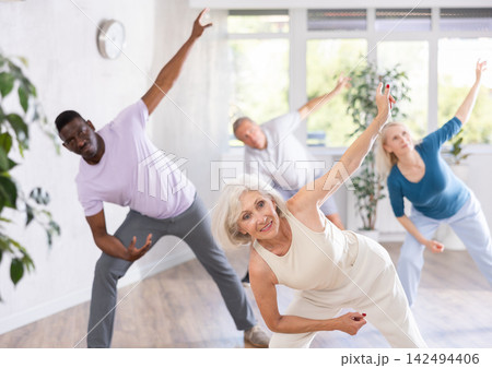 Active mature men and women practicing Jazz-funk dance in training hall 142494406