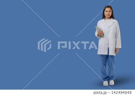 Medical worker stands holding a clipboard in a blue area 142494848