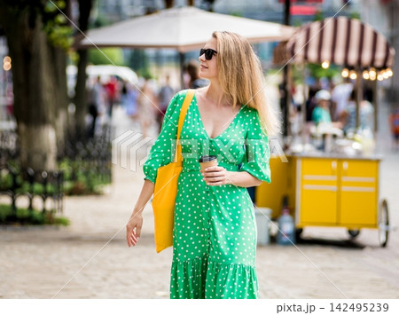 Young beautyful woman with yellow linen eco bag on city background. Young beautyful woman with yellow linen eco bag on city background. 142495239