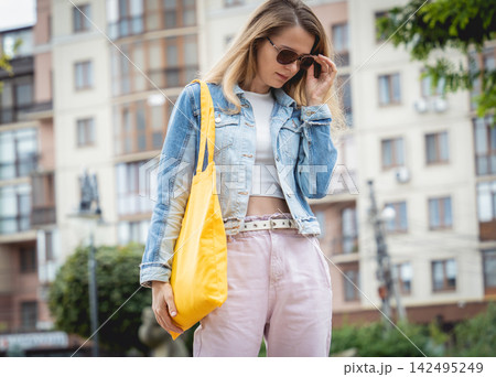 Young beautiful woman with linen eco bag on city background. Young beautiful woman with linen eco bag on city background. 142495249