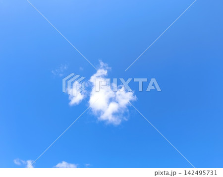 Single isolated white cloud in a clear bright blue sky. Sunny summer daytime weather background with extensive copy space Single isolated white cloud in a clear bright blue sky. Sunny summer daytime weather background with extensive copy space 142495731