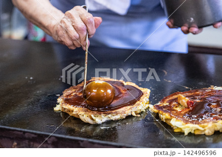 お好み焼きにたっぷりソースをかける瞬間 142496596