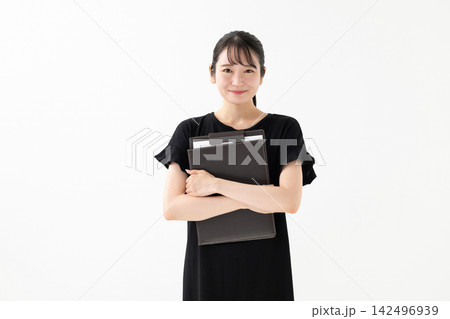 白い背景でバインダーを持って立つ女性 白い背景でバインダーを持って立つ女性 142496939