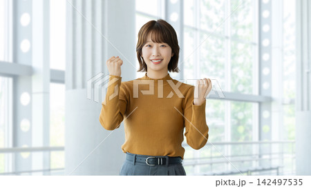 ガッツポーズをする女性・ビジネスウーマン ガッツポーズをする女性・ビジネスウーマン 142497535