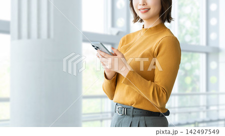 スマートフォンを持つ女性・ビジネスウーマン スマートフォンを持つ女性・ビジネスウーマン 142497549