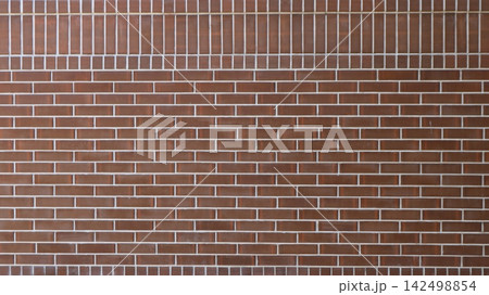 The floor is clad in brown glossy brick tiles. The main part is laid in a classic horizontal offset pattern, while the top row is vertical. Contrasting white grout emphasizes the strict geometry. 142498854
