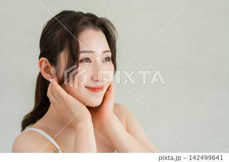 頬に手を添えて美肌を確認する大人女性のスキンケア,美容イメージ 頬に手を添えて美肌を確認する大人女性のスキンケア,美容イメージ 142499641