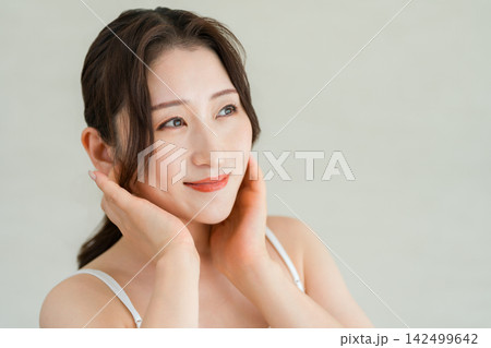 頬に手を添えて美肌を確認する大人女性のスキンケア,美容イメージ 頬に手を添えて美肌を確認する大人女性のスキンケア,美容イメージ 142499642