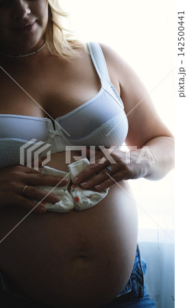 Pregnant Belly with Tiny Baby Socks, Expecting a Newborn, Pregnancy Announcement, Motherhood and Baby on the Way 142500441