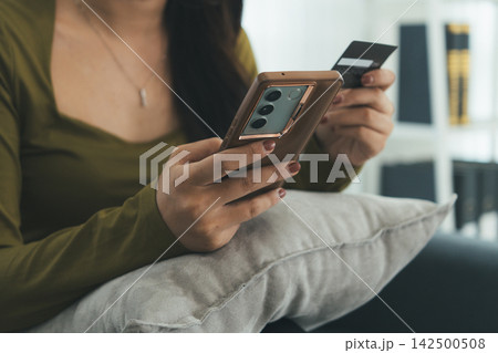 Young Asian Woman Studying Online with Laptop, Tablet, Smartphone and Headphones at Home, Adult Education and E-Learning 142500508