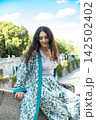 Elegant woman looking down thoughtfully in natural light outdoors 142502402