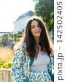 Happy adult female looking at camera with long hair outdoors 142502405