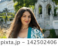 Close up headshot of beautiful middle aged brunette smiling in sunny daylight 142502406