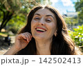 Close up headshot of happy laughing 38 year old Armenian woman outdoors 142502413