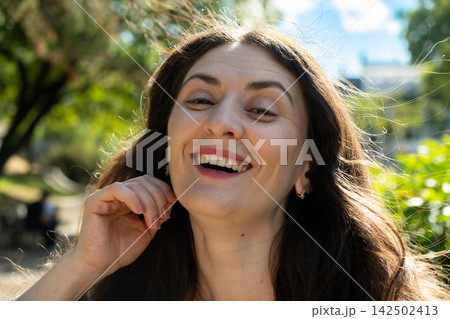Close up headshot of happy laughing 38 year old Armenian woman outdoors Close up headshot of happy laughing 38 year old Armenian woman outdoors 142502413