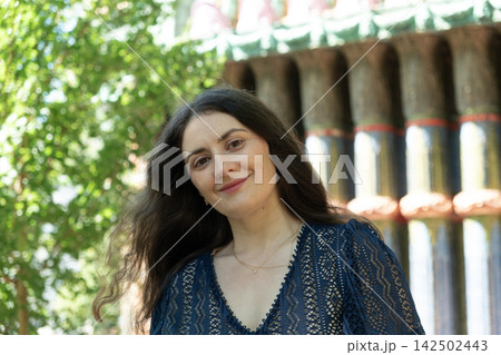 Beautiful adult Armenian woman looking directly at camera with gentle smile outdoors in sunlight Beautiful adult Armenian woman looking directly at camera with gentle smile outdoors in sunlight 142502443