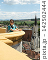 Woman tourist with backpack enjoying panorama of the old Austrian historical city. 142502444