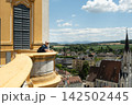 Male tourist with backpack looking down at the town from a historic balcony 142502445